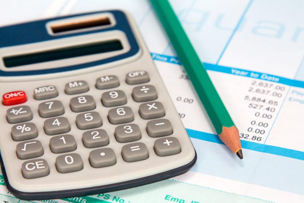 Image of a payslip, calculator and pencil.